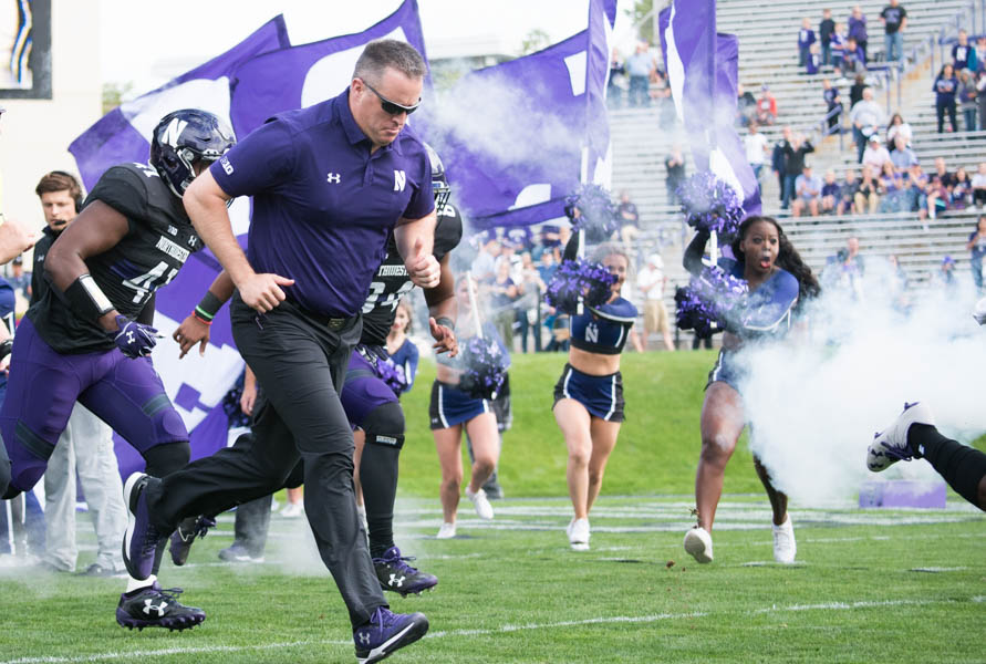 Pat Fitzgerald leads the Wildcats onto the field. Northwestern will face Kentucky in the Music City Bowl on Dec. 29.