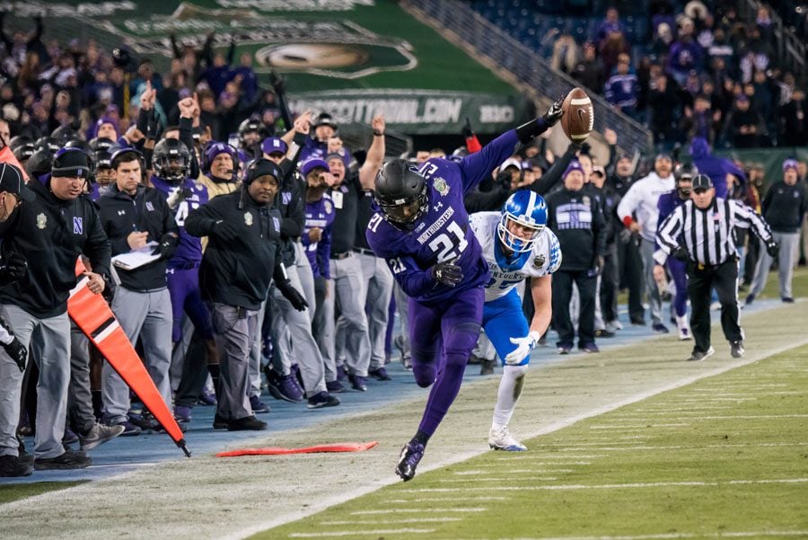 Kyle Queiro tiptoes down the sideline on an interception return. The senior safety scored a touchdown on the return to help Northwestern to a Music City Bowl victory.