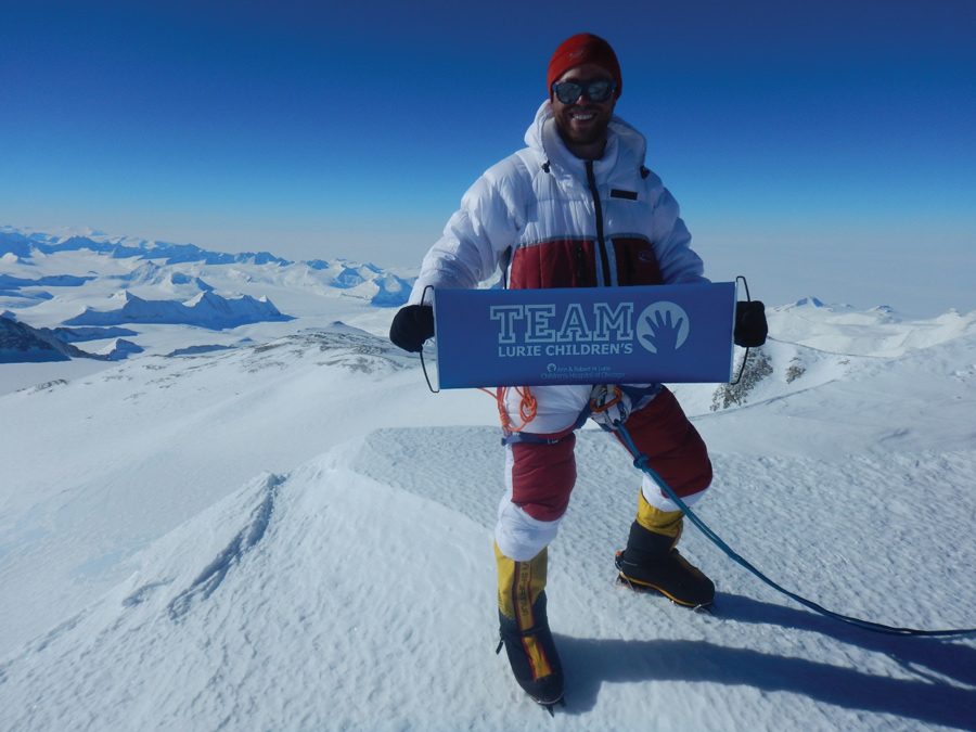 Alexander Pancoe (Weinberg ’09) holds a flag for Lurie Children’s Hospital at the summit of Mount Vinson in Antarctica. Pancoe raised $320,000 to donate to pediatric brain tumor research.
