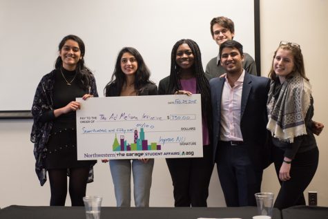 Weinberg sophomore Neha Basti receives a check after winning the Improve NU Challenge. Basti pitched The Ad Meliora Initiative to create mental health resilience programming. 