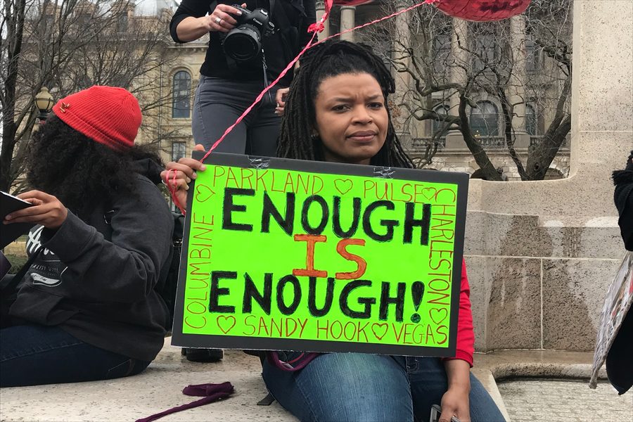 Rally participant Karla Thomas displays her sign, reading “enough is enough.” Evanston residents went to Springfield to join other protestors seeking gun control.