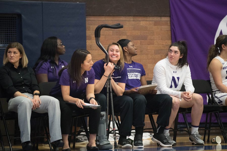Lydia Rohde smiles on the bench while out with an injury. The senior guard’s good friend, junior forward Pallas Kunaiyi-Akpanah, said Rohde’s bright teeth were the first thing she noticed about her.