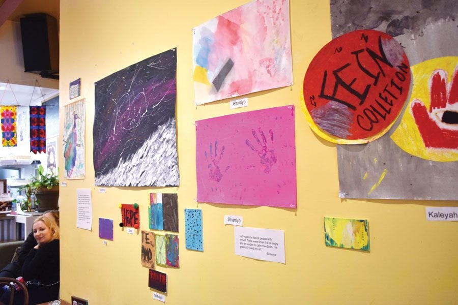 Trainees at Curt’s Café South, 1813 Dempster St., showcase their artwork at the exhibition’s opening night. Several artists said they were able to express themselves through their art. 