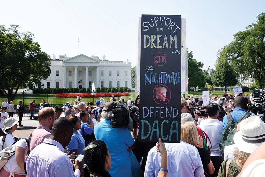 Protesters hold up signs during a rally supporting Deferred Action for Childhood Arrivals, or DACA, outside the White House on September 5, 2017. A federal judge ruled Tuesday that the Trump administration must resume the DACA program and accept new applicants.