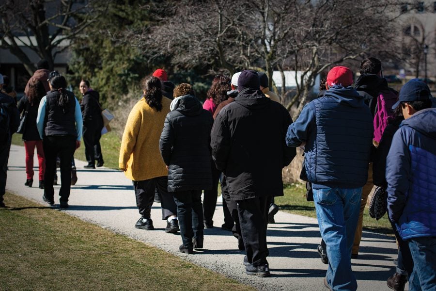 Northwestern’s Sodexo and Aramark employees march Friday to present a petition asking the companies to help with the transition to Compass Group North America. The demonstrators raised concerns about possible drug tests, background checks and participation in the E-verify program. 