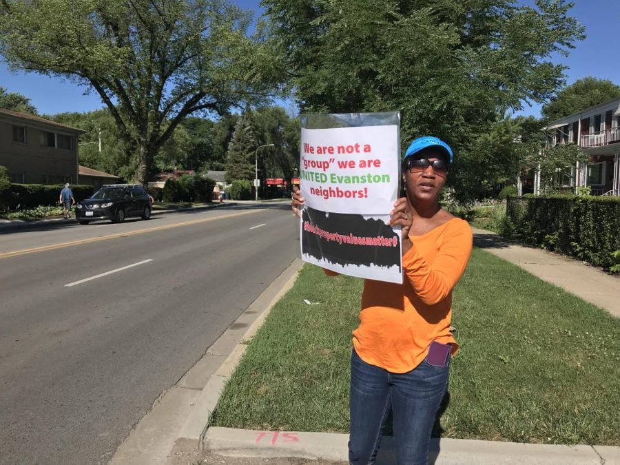 Evanston resident Carolyn Murray stands with a sign protesting a housing project at 2215 Dempster St. Murray was among other Evanston residents protesting the new development early Wednesday morning. 