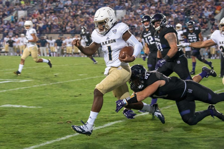 Akron quarterback Kato Nelson scampers away from Northwestern defenders. The loss dropped the Wildcats nonconference record dating back to 2016 to 3-5.