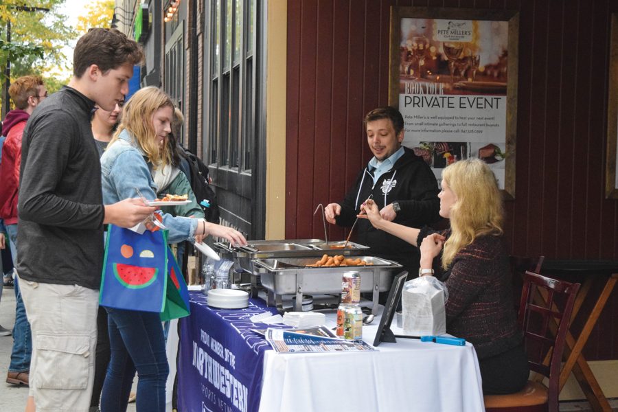 Students collect free samples at Big Bite Night. The annual event featured 33 restaurants that handed out samples and promotional materials to students and other attendees.
