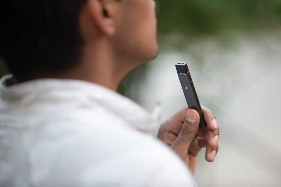 A person vapes using a Juul. A commentary published in September by NU researchers says electronic cigarettes like Juul should be viewed as separate products from regular cigarettes. 