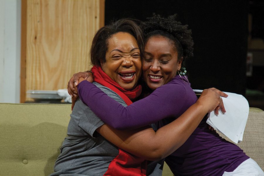 Two actors embrace while rehearsing for “Familiar.” The show, written by actor/playwright Danai Gurira, focuses on a family of Zimbabwean-Americans living in Minnesota. 