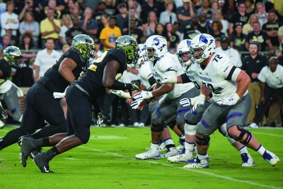 Several offensive linemen prepare to engage blocks. The Wildcats have picked up their play in recent weeks.
