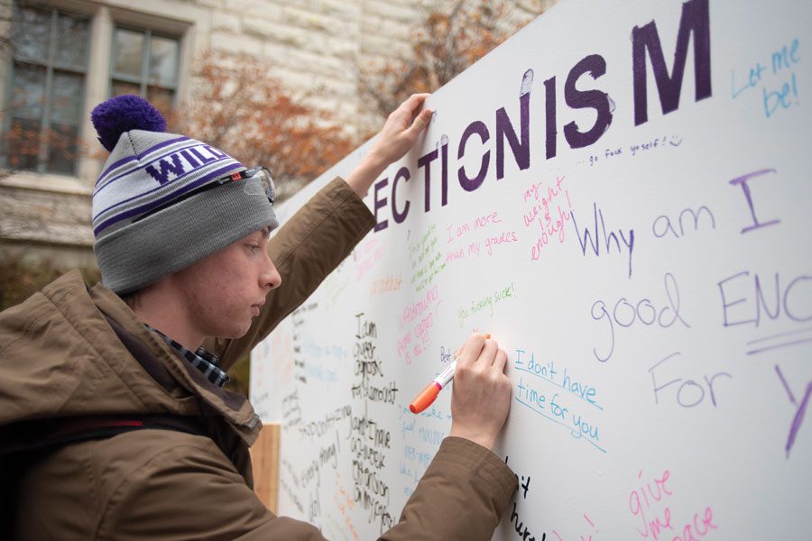Kevin Stoffel, Weinberg senior, writes on a board titled “Dear Perfectionism.” The Family Institute’s #PerfectlyImperfectNU campaign encourages students to “flaunt their flaws” and speak up if they need help with the pressures of school.