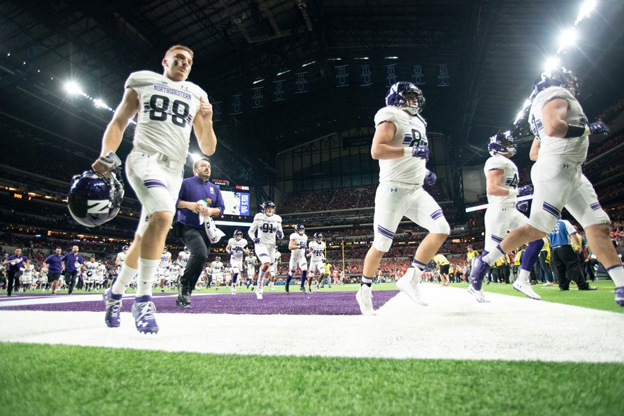 The Cats run out at the 2018 Big Ten Championship Game. Pat Fitzgerald said Saturday that he will not rush to name NU’s starting quarterback.