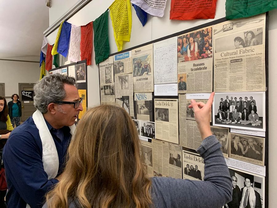 Exhibit-goers browse newspaper clippings from the the period when the Tibetan refugee community began to settle in Chicago. In addition to the articles, the “Tibetans in Chicago: A story of resilience and success” exhibit includes portraits, photos and letters. 