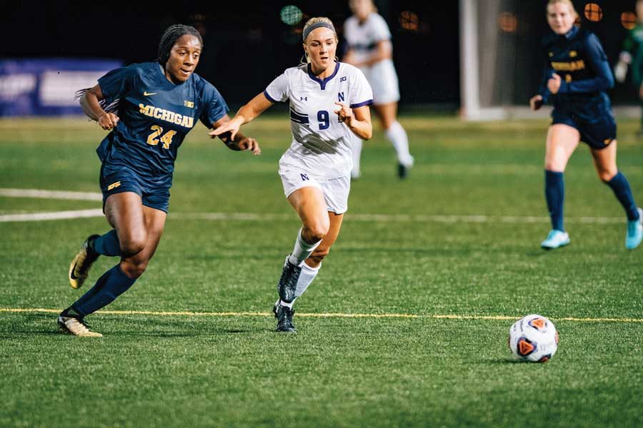 Kayleigh Stahlschmidt dribbles between two defenders. The junior forward said NU’s newcomers are already a big part of this year’s team.