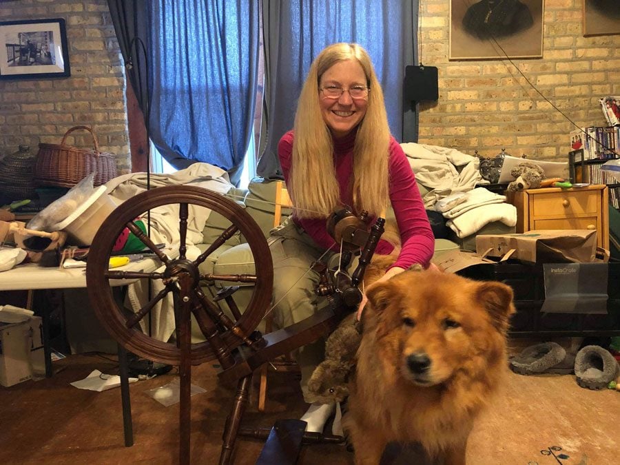 Jeannie Sanke poses with her dog Kaya next to her spinning wheel. Sanke runs Knit Your Dog, a business that will turn dog hair into knitted garments.