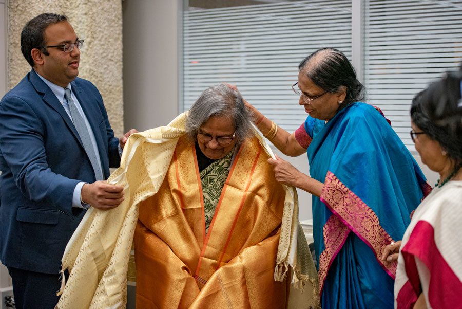 Sen. Ram Villivalem (D-Skokie) (left) and Dharani Villivalem (right) honor Ela Gandhi (center) Thursday at Skokie Public Library.