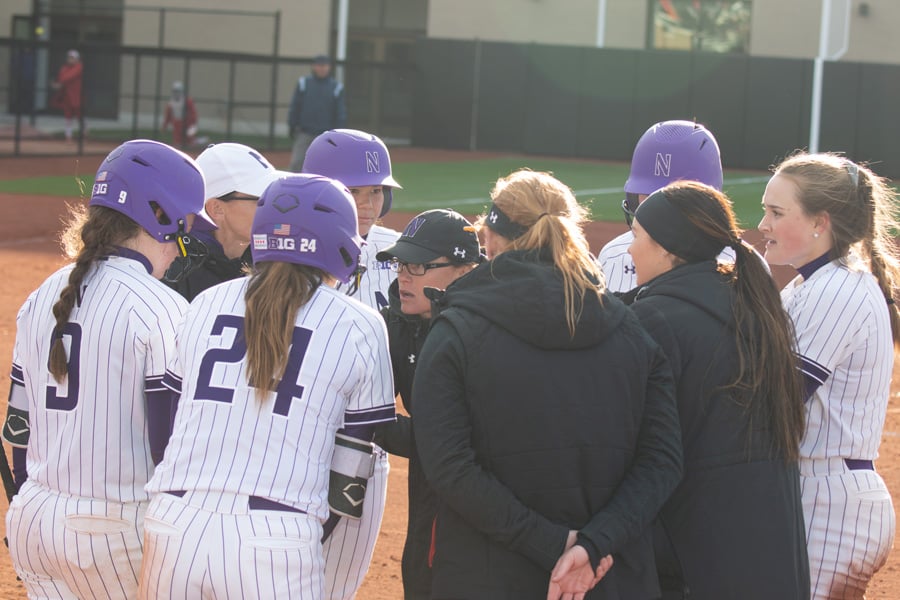 Northwestern holds a meeting near home plate. The Wildcats open their season this weekend.