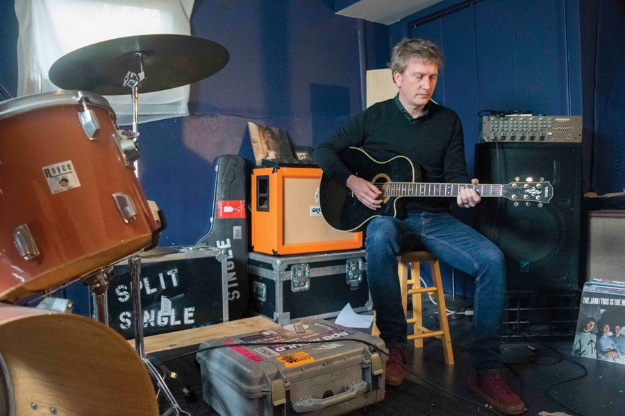 Jason Narducy plays guitar in his home practice space. Narducy wrote the score for the musical Verböten, which is based on his childhood band. 
