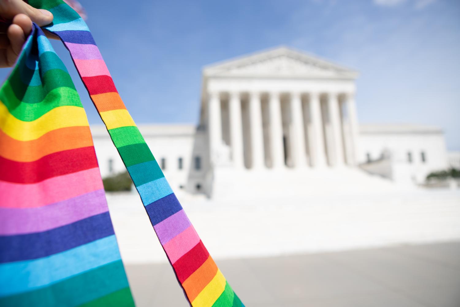 A+rainbow+stole+held+in+front+of+the+Supreme+Court+building+on+June+15%2C+2020%2C+the+day+the+Court+extended+civil+rights+protections+to+LGBTQ+employees.