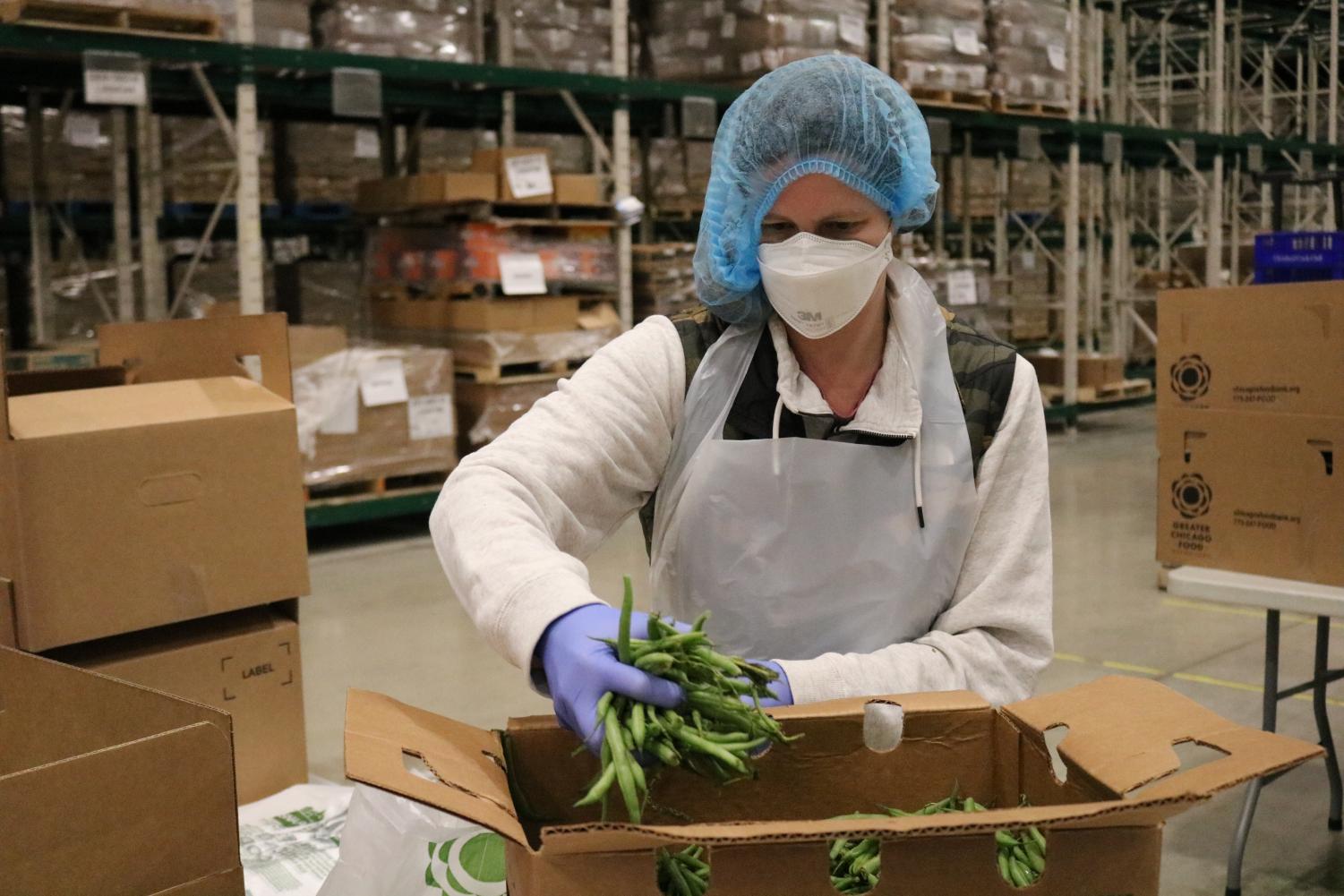 A+volunteer+packs+produce+at+the+Greater+Chicago+Food+Depository%E2%80%99s+warehouse.