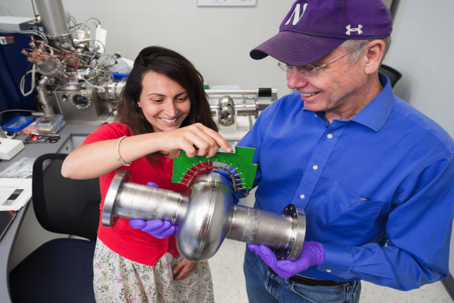 SQMS director Anna Grassellino and deputy director James Sauls hold a superconducting radio-frequency cavity at Fermilab. These cavities play a pivotal role in developing quantum technologies. 