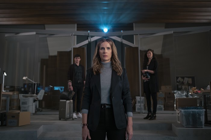 Gretchen Klein stands in the control room as she and her co-conspirators watch the girls struggle to survive on a deserted island. 