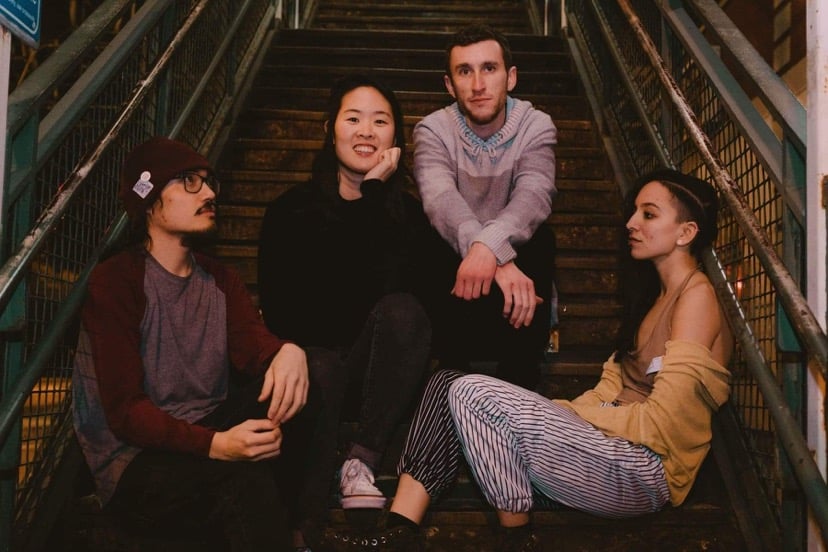 Matthew Bactat, Claire Zhang, Ethan Urborg and Taylor Ericson, the members of splits, pose for a photo in front of an El station. Their newest EP, “vice versa,” released this month. 