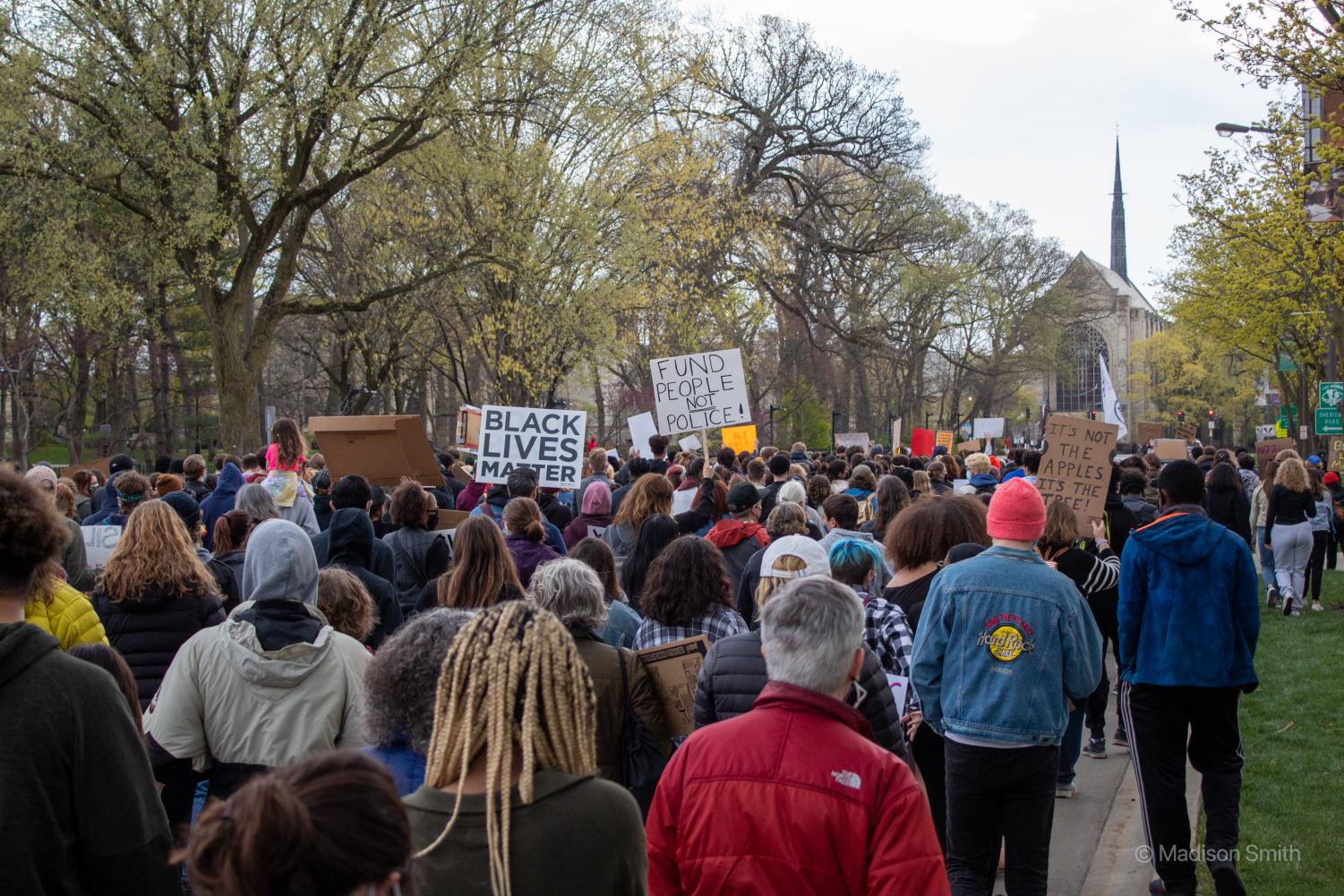 A+large+crowd+of+protesters+march+down+a+street+towards+a+church.+Some+hold+signs+with+the+words+%E2%80%9CBlack+Lives+Matter%2C%E2%80%9D+%E2%80%9CFund+people+not+police%E2%80%9D+and+%E2%80%9CIt%E2%80%99s+not+the+apples+it%E2%80%99s+the+tree.%E2%80%9D