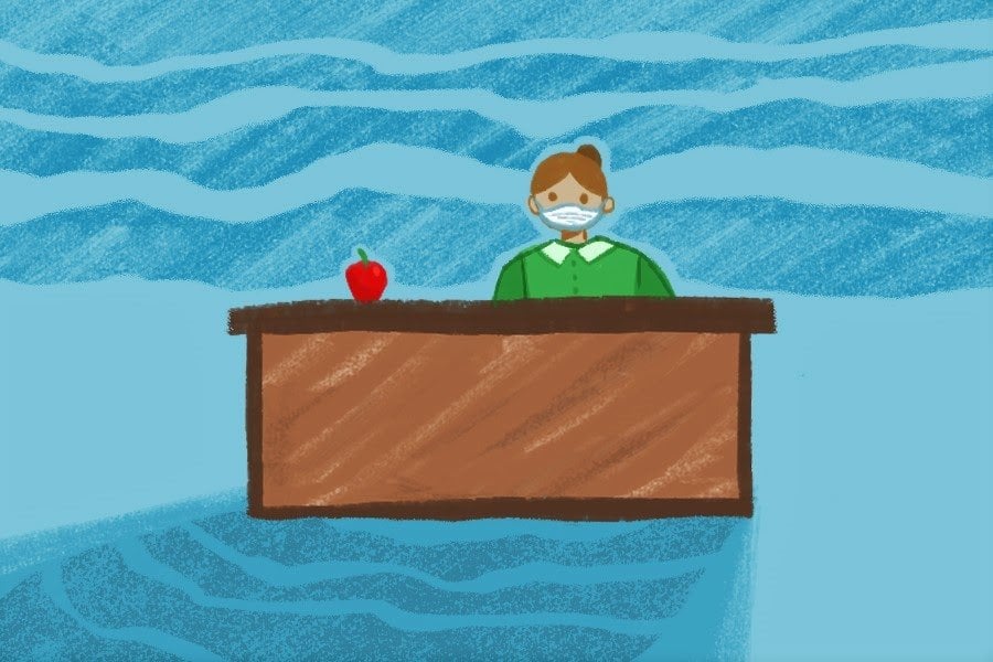 Girl in green shirt sitting at desk with a red apple