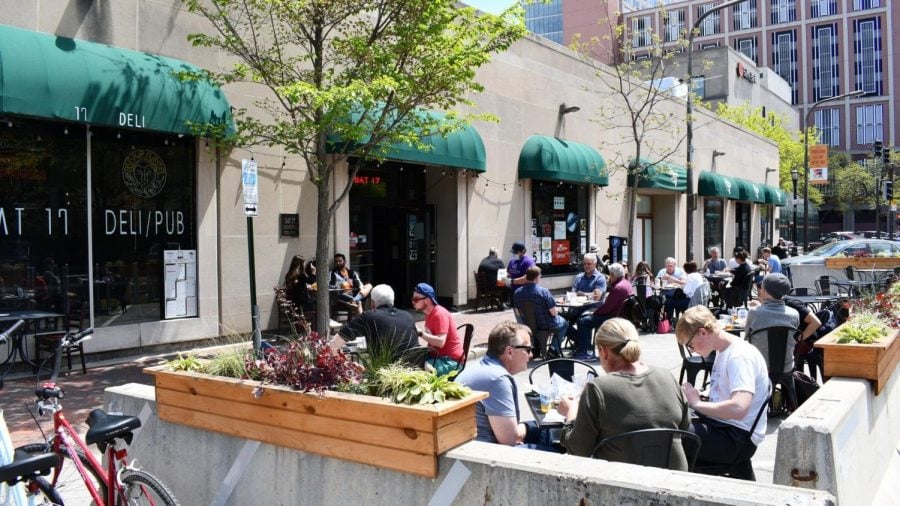 A+sidewalk+cafe+enclosed+by+barriers+and+on+the+parking+spaces+is+filled+with+customers+on+a+sunny+Friday+afternoon.
