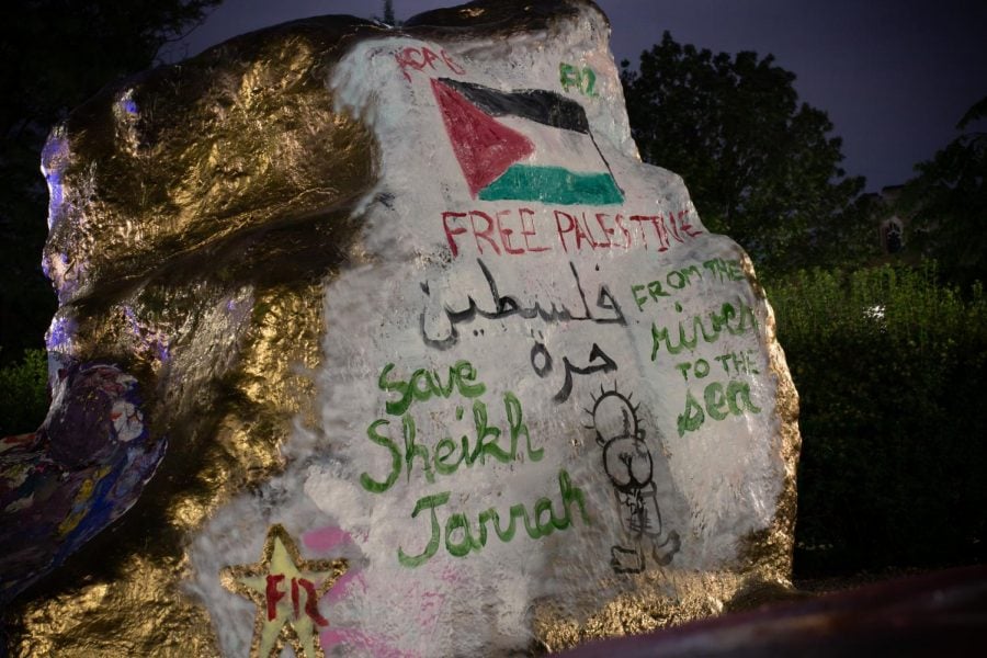 A photo of The Rock painted gold and white with pro-Palestine messages. Adorning its surface is the flag of Palestine, “Free Palestine” in red and “save Sheikh Jarrah” in green.
