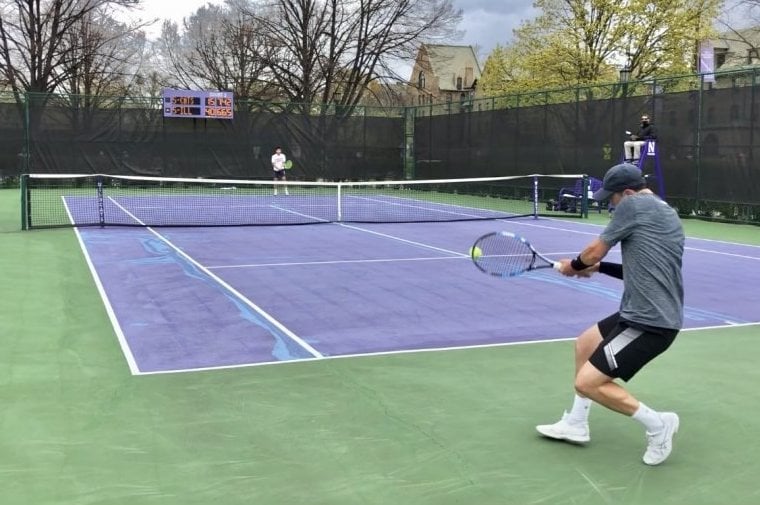 A male tennis player hits a ball