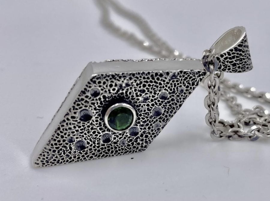 A silver diamond-shaped pendant. Local artist Stephan Collins recently returned to silversmithing full-time.