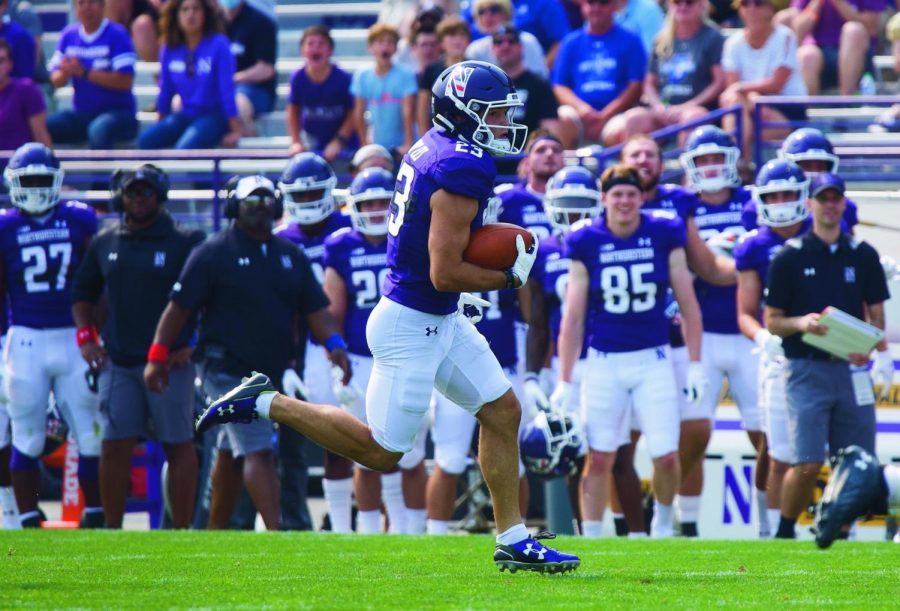 A Northwestern player runs down the field with the ball on a punt return.