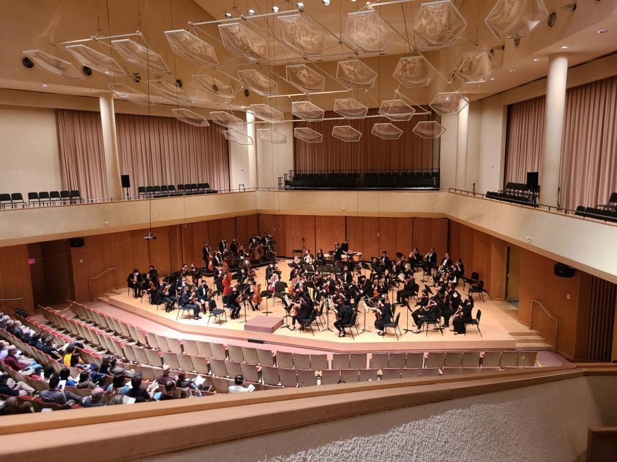 The stage in Pick-Staiger Concert Hall. The musicians are seated with their instruments.