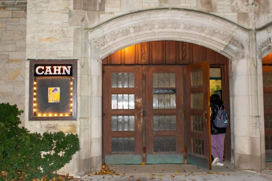 The exterior of Cahn Auditorium. A student is entering the door.