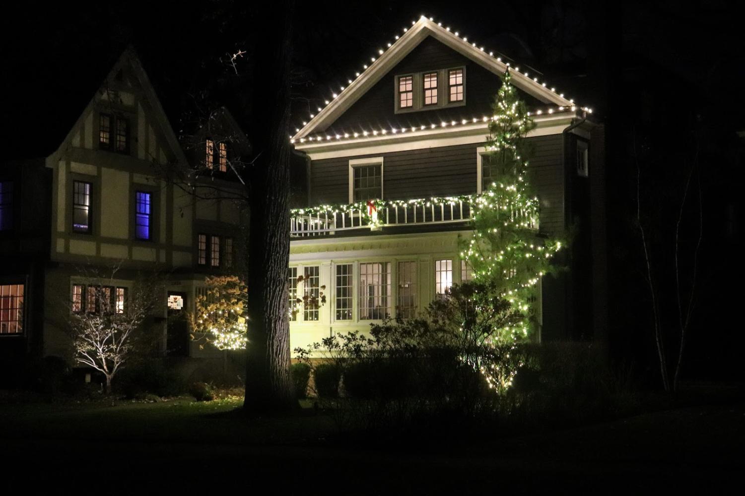 A+house+has+white+string+lights+bordering+the+roof%2C+and+lights+wrap+around+a+tree+in+the+front+yard.+The+house+also+has+garland+and+white+lights+wrapped+around+its+second-floor+balcony.