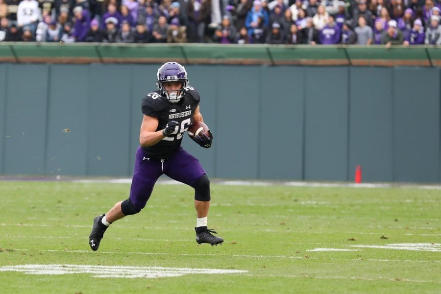 Northwestern football player carries the football.