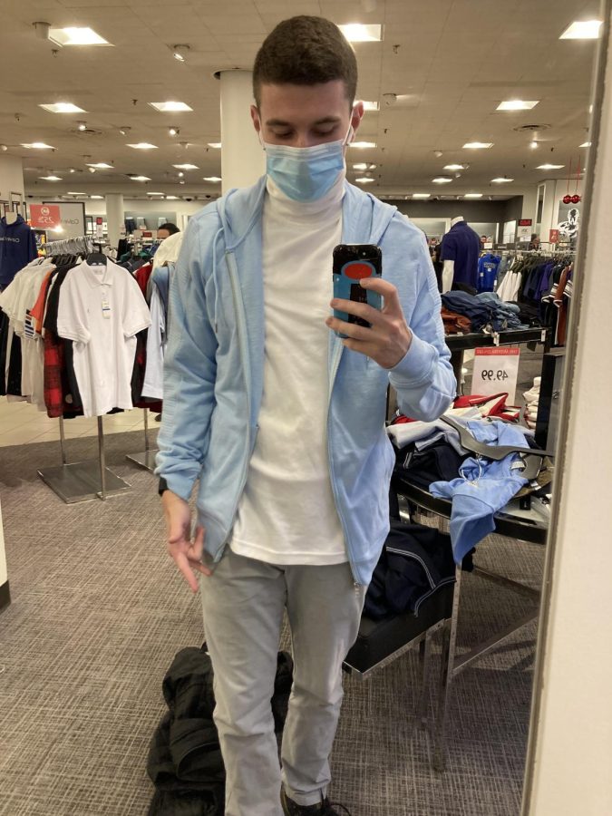 A man in blue jacket poses in a department store.
