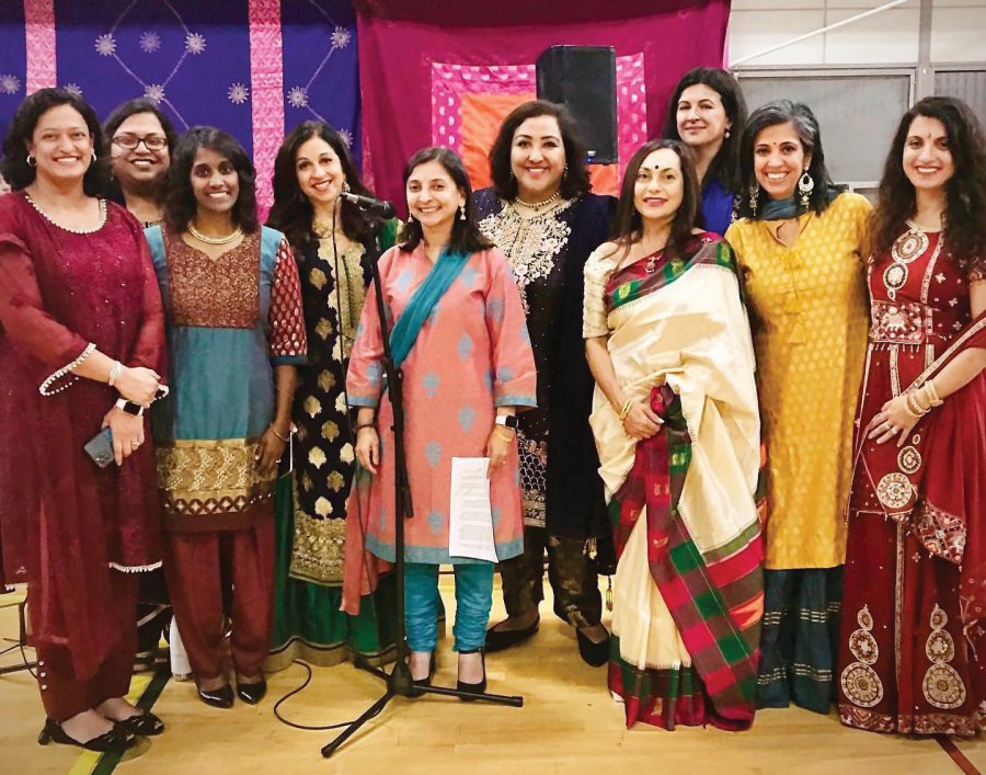 A+group+of+women+dressed+in+traditional+Indian+attire%2C+members+of+the+South+Asian+Women+of+Evanston+group%2C+pose+in+front+of+one+purple+and+one+pink+tapestry.
