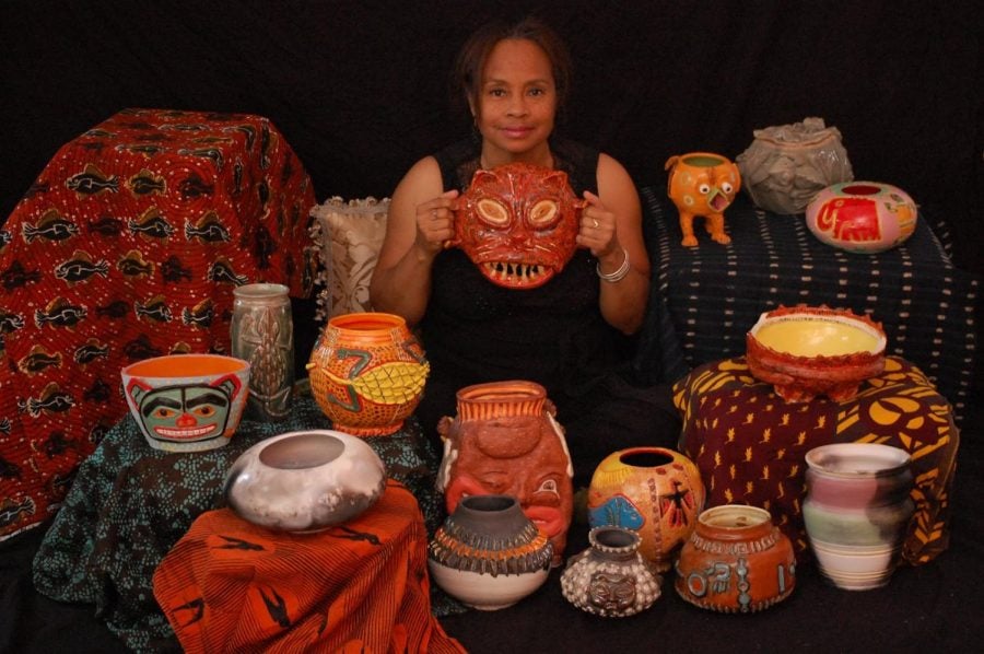 Cherie+Lockett+sits+surrounded+by+14+pieces+of+her+pottery%2C+holding+an+orange+ceramic+mask+of+a+cat+that+she+created.