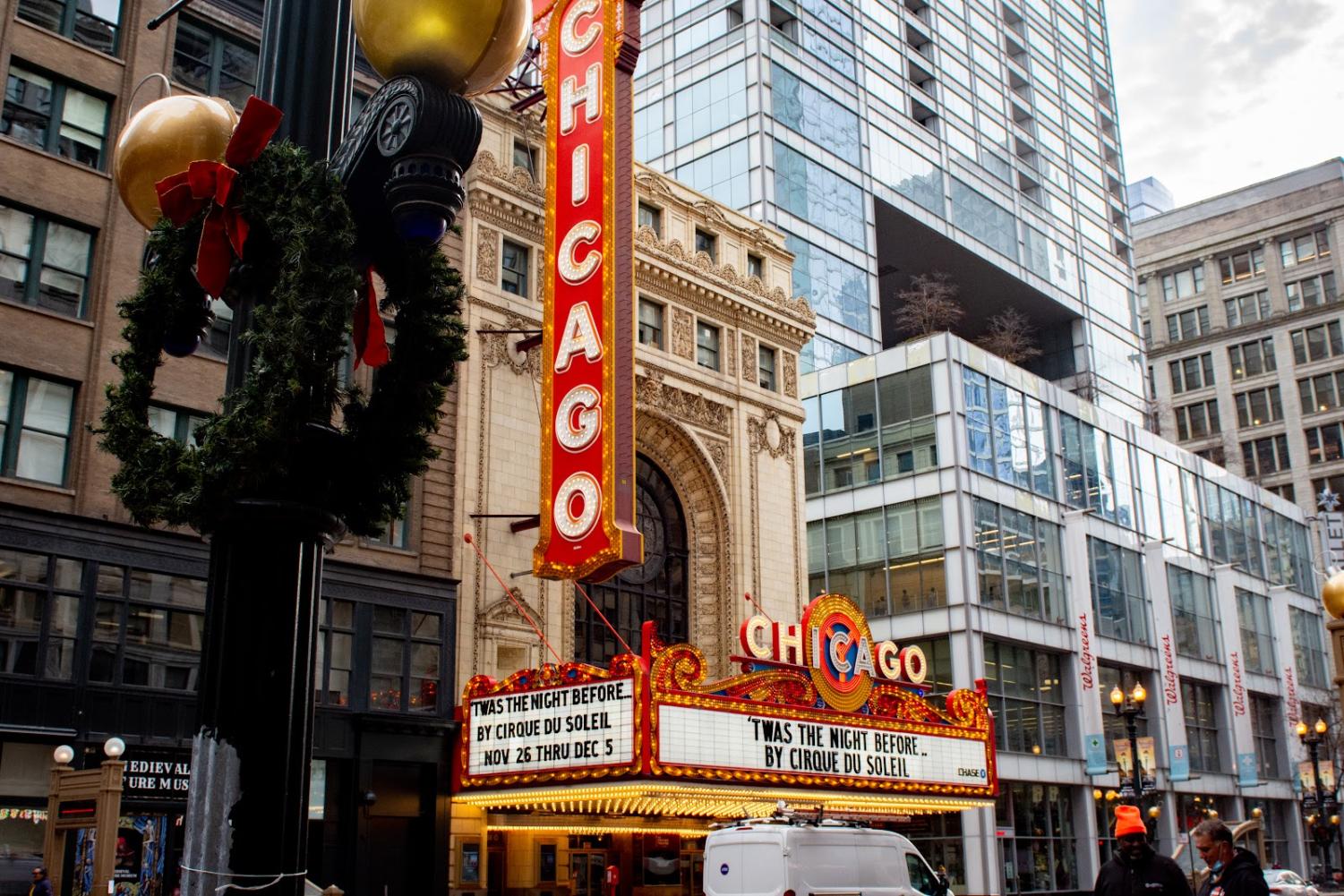 Red+vertical+sign+and+theater+banner+that+says+%E2%80%9CChicago%E2%80%9D+in+white+capital+letters.+To+the+left+on+a+black+pole+is+a+green+wreath.