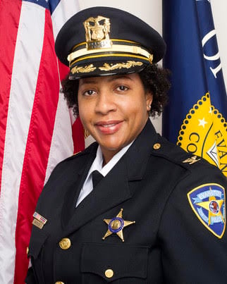 Interim Police Chief Aretha Barnes poses in front of the American flag and the City of Evanston flag for a department headshot.