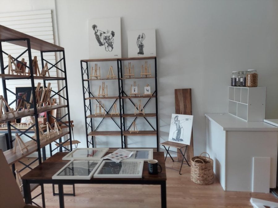 Shelves with small easels and art prints line the walls of the new gallery
