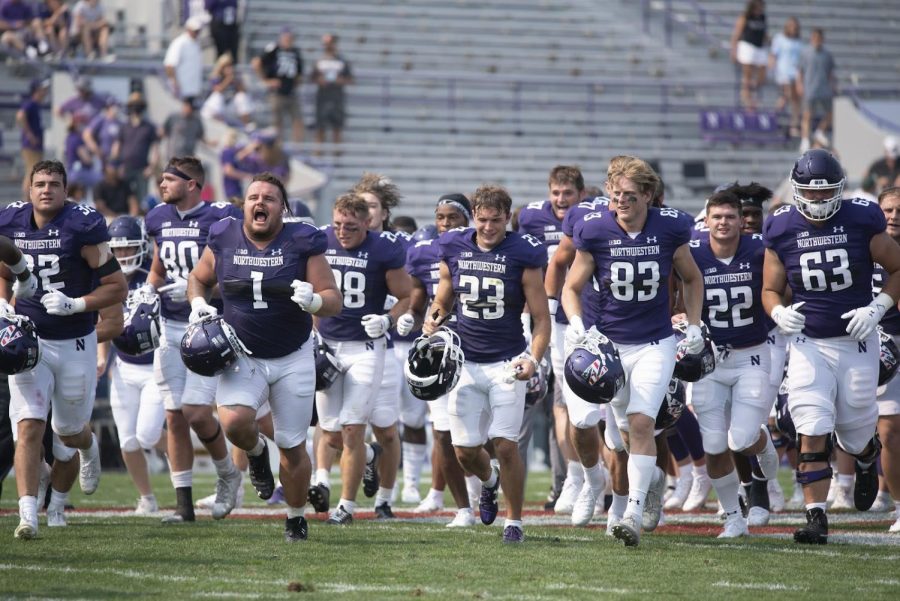 Northwestern players celebrate a 2021 win over Indiana State. The Wildcats may find wins hard to come by in 2022, Sports Editor Patrick Andres writes.