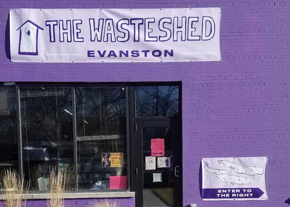 The+exterior+of+a+storefront.+The+wall+is+brick+painted+purple.+A+large+banner+above+the+door+reads%2C+%E2%80%9CThe+WasteShed+Evanston%2C%E2%80%9D+also+in+purple.+There+is+a+purple+sign+with+whales+on+it+that+reads%2C+%E2%80%9CEnter+to+the+right.%E2%80%9D