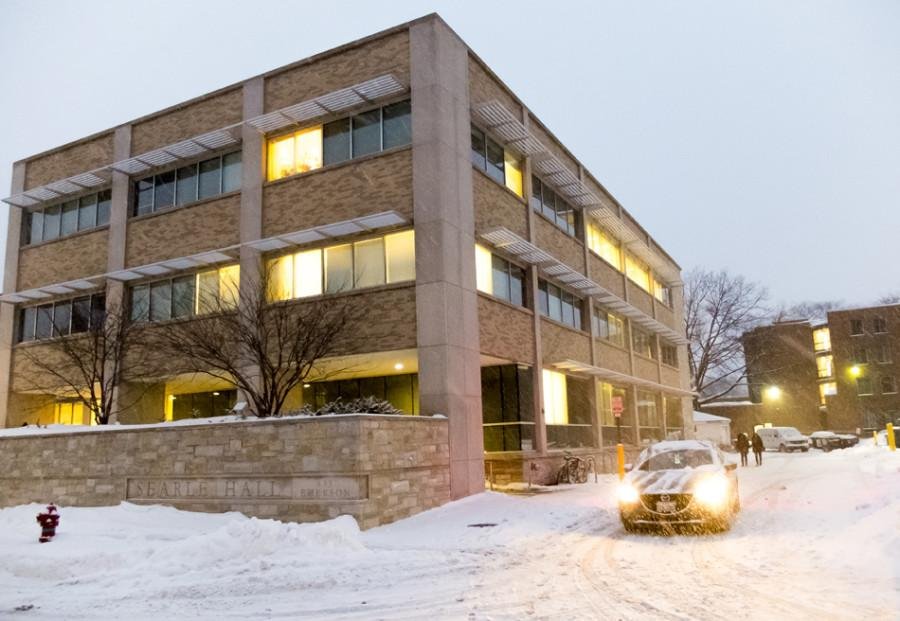 Photo of Searle Hall surrounded by snow and a parked car with headlights.