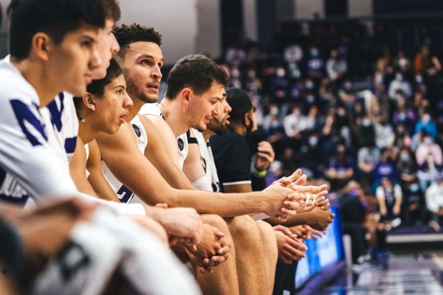 Northwestern players watch the game from the bench. The team couldn’t secure the victory Wednesday against Michigan, dropping the contest 72-70.