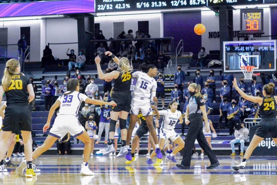 Two players bump into each other as the basketball flies to the right.